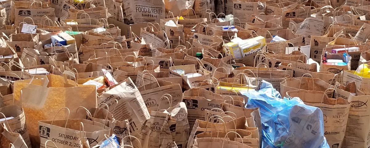 Bags filled with food and toiletries fill a parking lot
