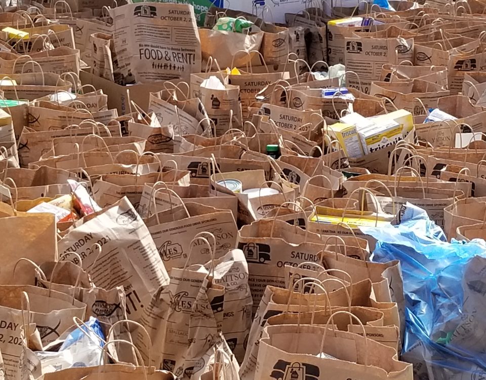 Bags filled with food and toiletries fill a parking lot