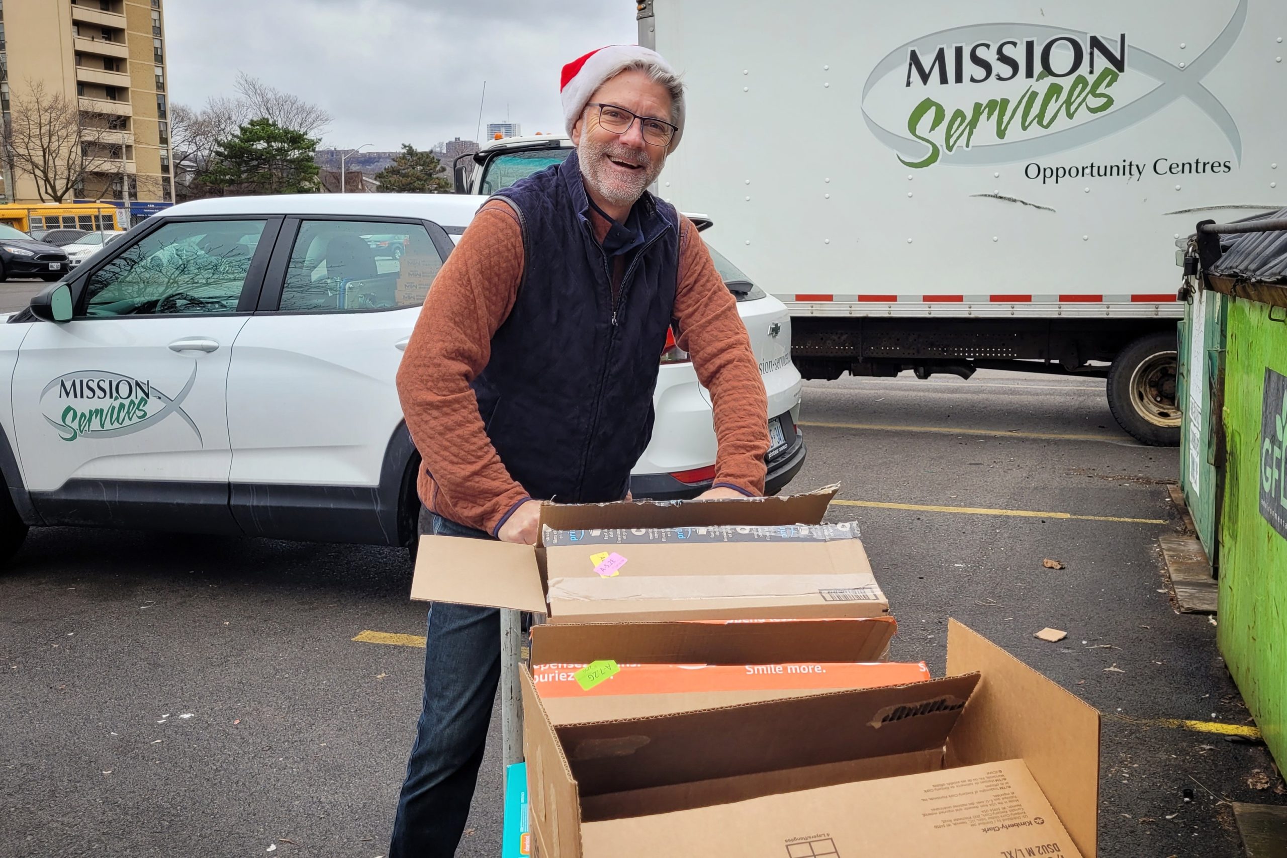 Stephen Dunn wearing a Santa hat, pushing a cart with donations