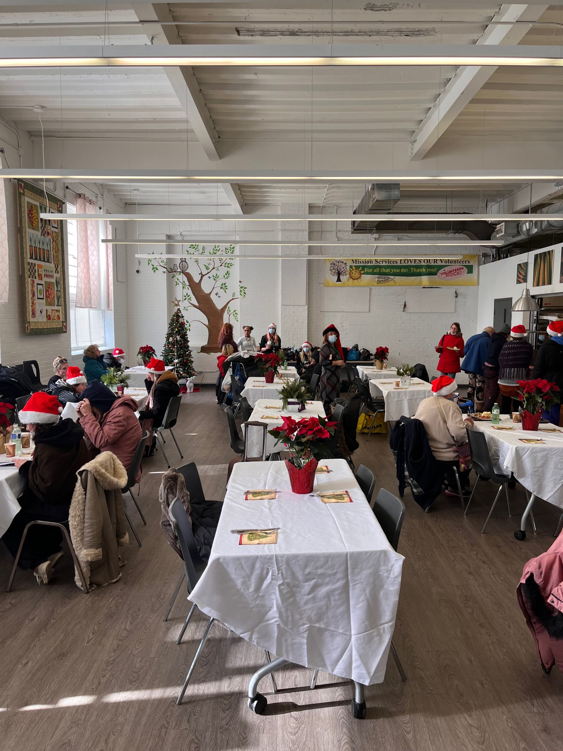 Large dining room decorated for Christmas with clients eating dinner