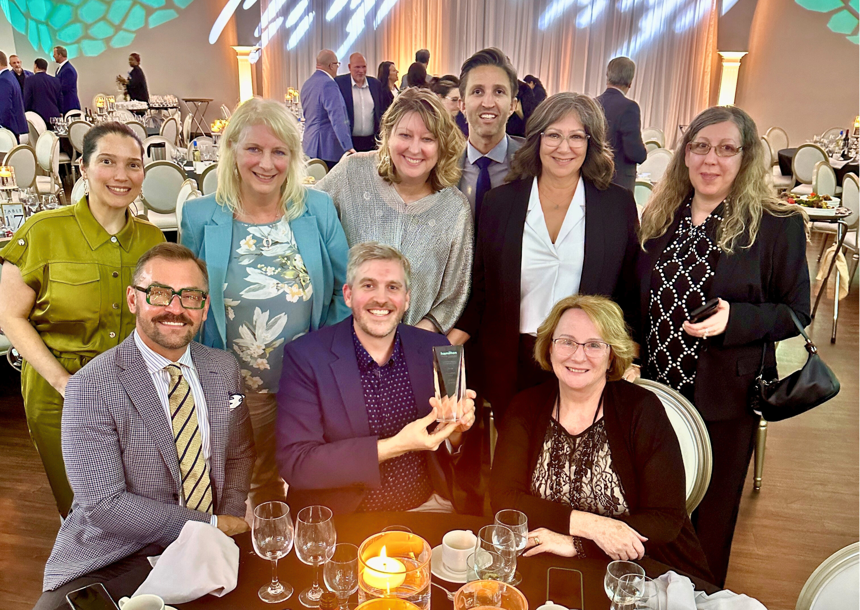 Photo of Mission Services Executive Team and some board members at a banquet holding an award