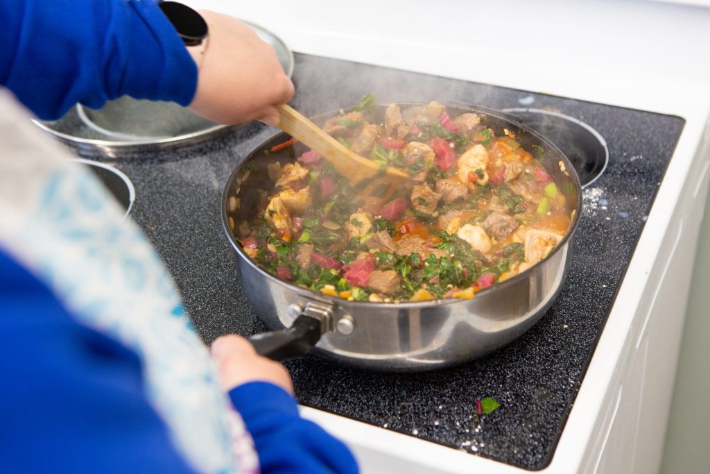 A pan with food being cooked on a stove top
